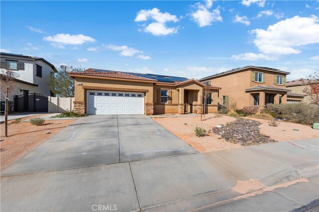 view of front facade featuring a gate, solar panels, stucco siding, concrete driveway, and a garage