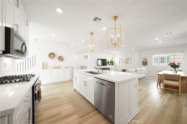 kitchen with open floor plan, visible vents, appliances with stainless steel finishes, and a sink