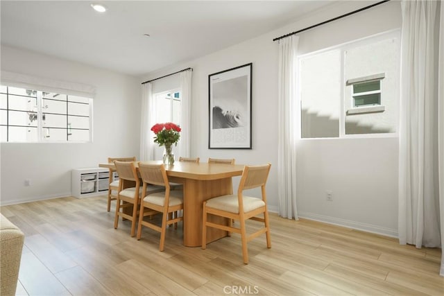 dining area featuring light wood-style flooring and baseboards