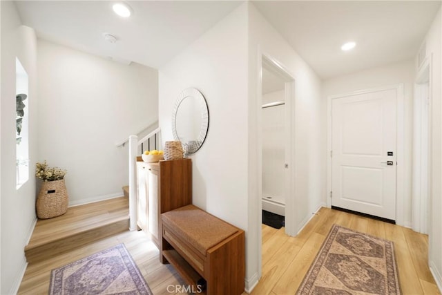 corridor featuring stairs, recessed lighting, light wood-type flooring, and baseboards