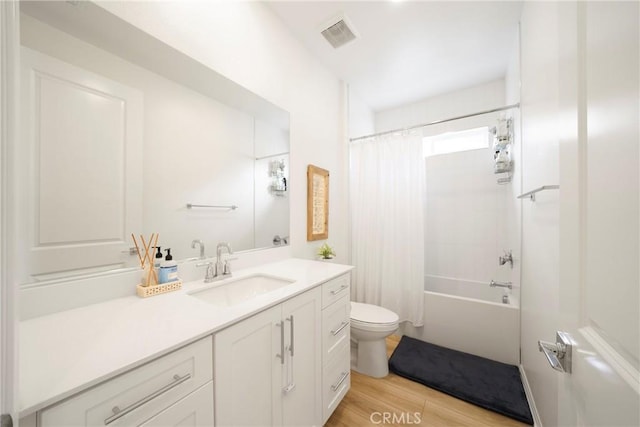 full bath with visible vents, shower / tub combo with curtain, toilet, wood finished floors, and vanity