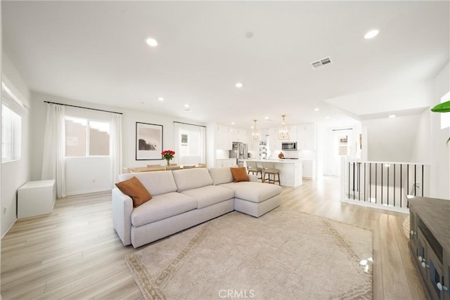 living area with recessed lighting, visible vents, and light wood-type flooring