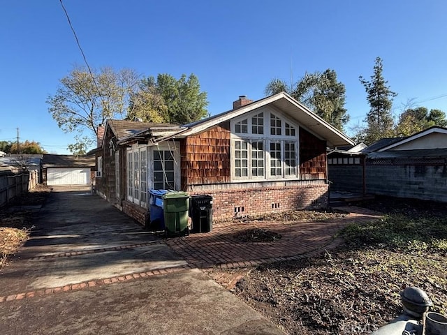 view of home's exterior with crawl space, a chimney, and fence