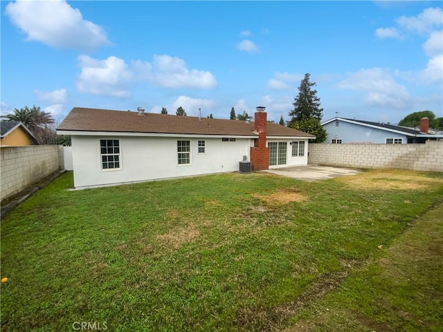 rear view of property featuring a patio, a fenced backyard, a lawn, and stucco siding