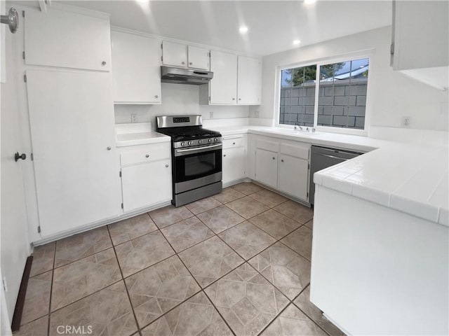 kitchen featuring under cabinet range hood, a sink, white cabinetry, recessed lighting, and appliances with stainless steel finishes