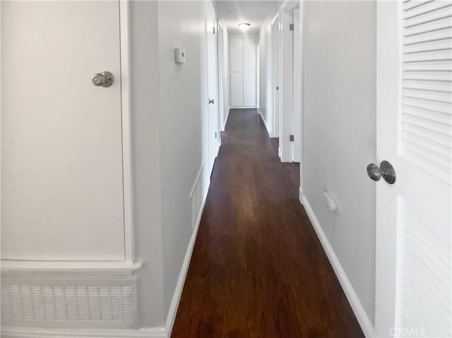 hall featuring baseboards and wood finished floors