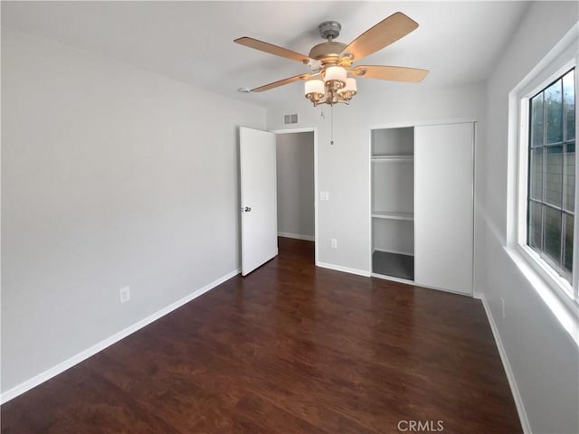 unfurnished bedroom with visible vents, a ceiling fan, wood finished floors, a closet, and baseboards