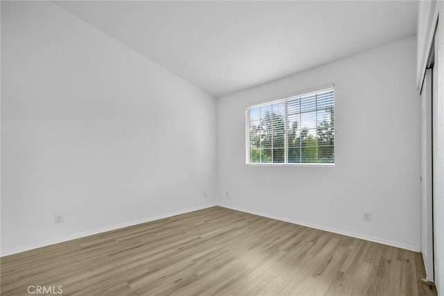 empty room featuring light wood-style floors and baseboards