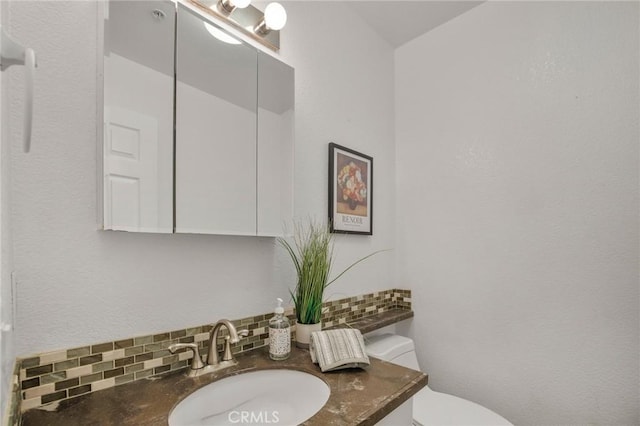 half bath with tasteful backsplash, toilet, and vanity