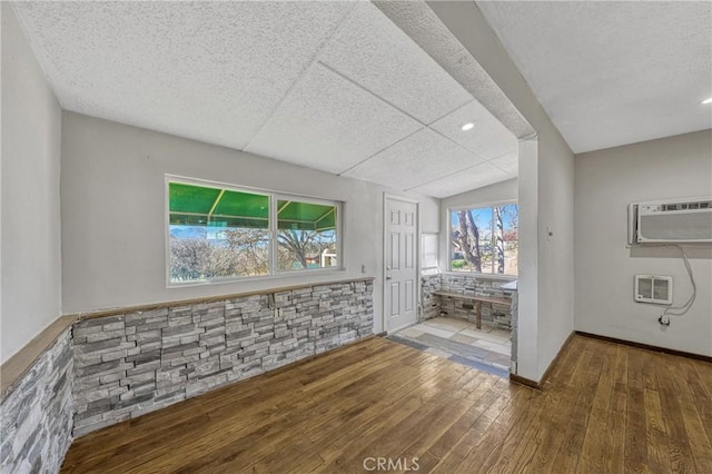 empty room featuring hardwood / wood-style flooring and a wall mounted AC