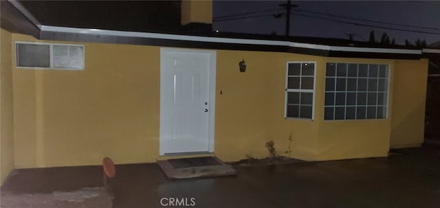 property entrance featuring stucco siding