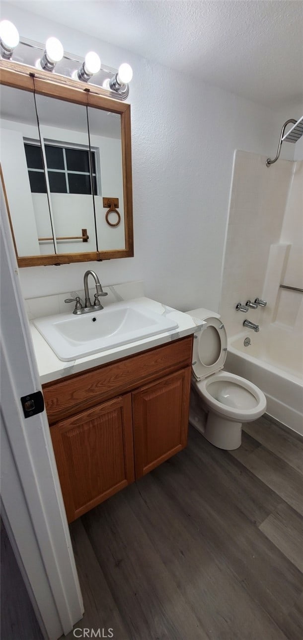 full bathroom featuring vanity, shower / bath combination, wood finished floors, a textured ceiling, and toilet