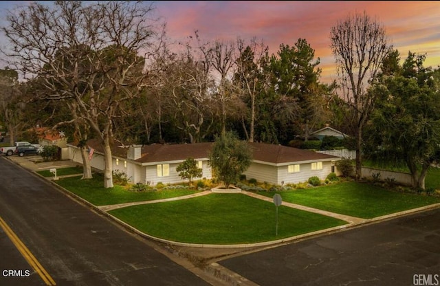 view of front of home with a front yard and fence