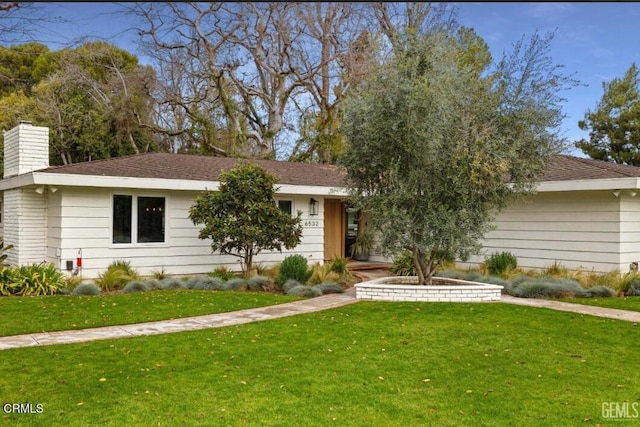 view of front of property featuring a front lawn and a chimney