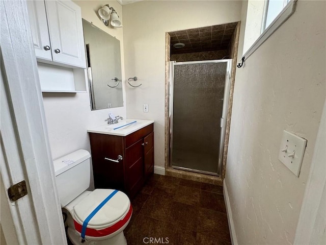 full bath featuring toilet, a stall shower, tile patterned flooring, baseboards, and vanity