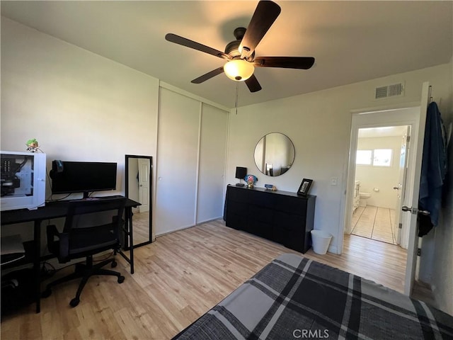 office area with light wood finished floors, visible vents, and ceiling fan