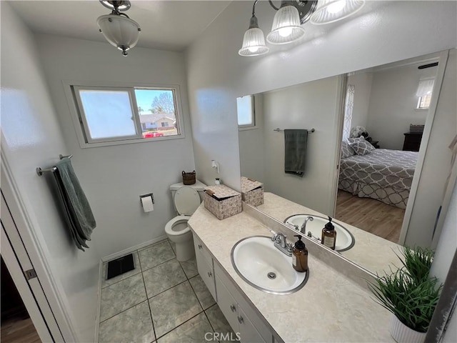 ensuite bathroom with visible vents, toilet, ensuite bathroom, tile patterned floors, and vanity