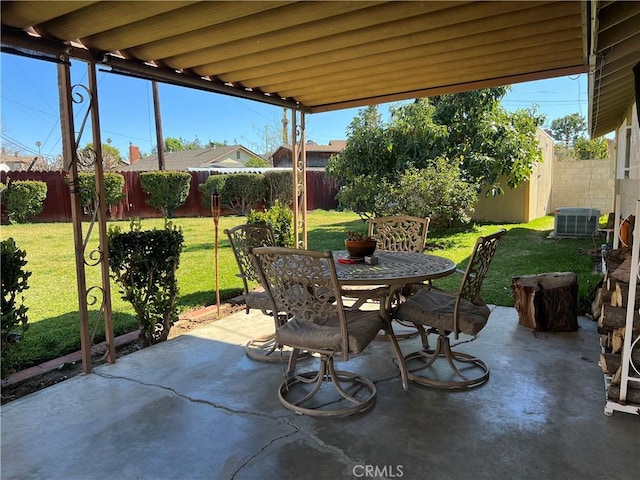 view of patio featuring outdoor dining space, cooling unit, and a fenced backyard