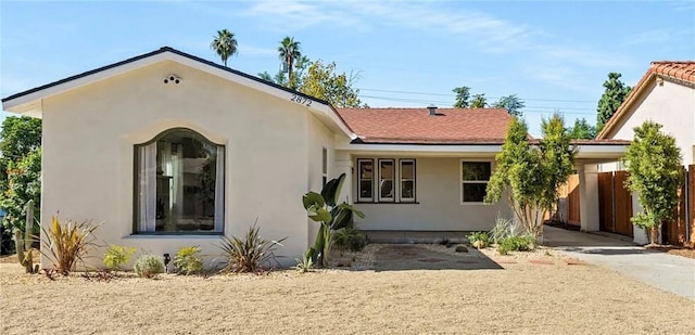 view of front facade featuring fence and stucco siding