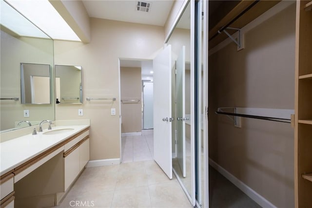 bathroom with tile patterned flooring, vanity, baseboards, and visible vents