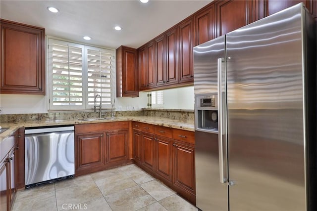 kitchen with light stone counters, light tile patterned floors, recessed lighting, a sink, and stainless steel appliances