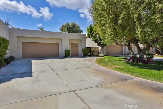 adobe home featuring stucco siding, driveway, and a garage