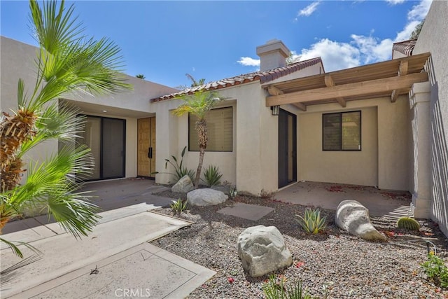 property entrance featuring stucco siding and a tiled roof