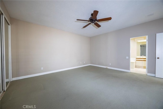 unfurnished bedroom featuring a closet, ensuite bath, carpet, and baseboards