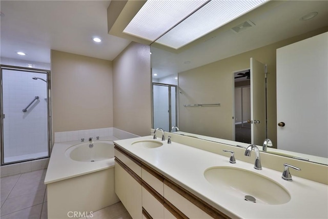 bathroom featuring tile patterned flooring, a bath, a stall shower, and a sink