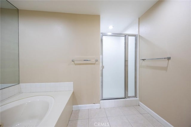 full bath with tile patterned flooring, a stall shower, a bath, and baseboards