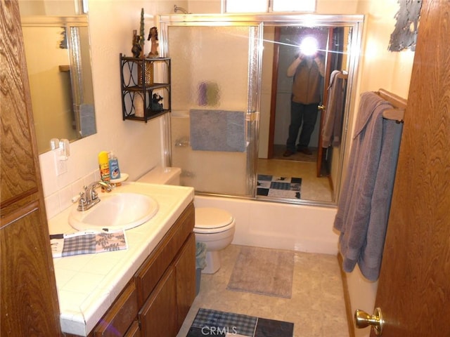 bathroom with shower / bath combination with glass door, toilet, and vanity