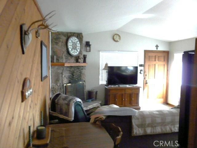 living area featuring wood walls and vaulted ceiling