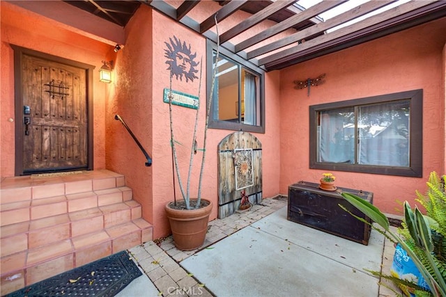 doorway to property with stucco siding and a patio