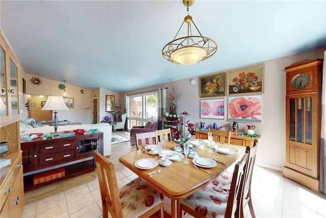 dining room featuring light tile patterned floors and vaulted ceiling