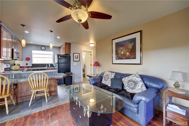 living area with dark wood-type flooring and ceiling fan