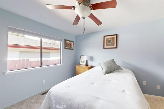 carpeted bedroom featuring visible vents and ceiling fan