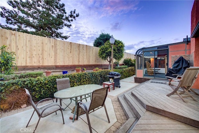 deck with outdoor dining space and a fenced backyard