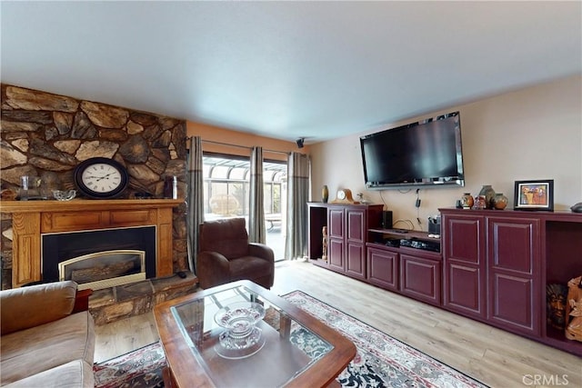 living area featuring light wood-style flooring and a fireplace