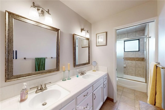 full bath featuring tile patterned flooring, combined bath / shower with glass door, double vanity, and a sink