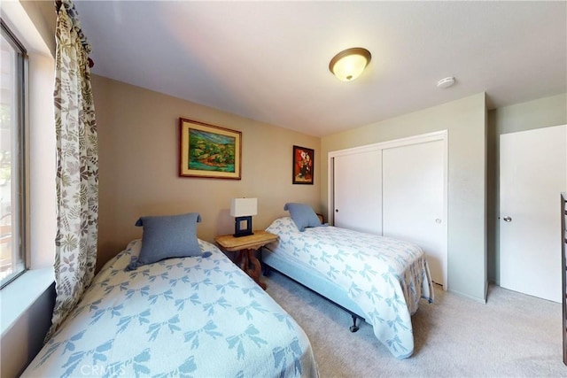 bedroom with a closet and light colored carpet