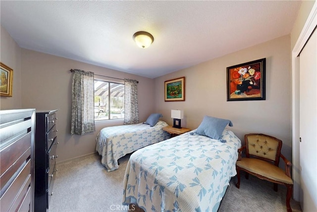 bedroom featuring baseboards, a closet, and light carpet