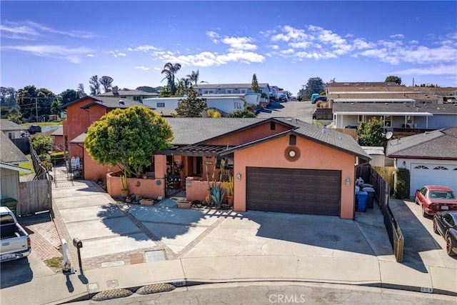 view of front of house with a gate, driveway, an attached garage, a fenced front yard, and a residential view