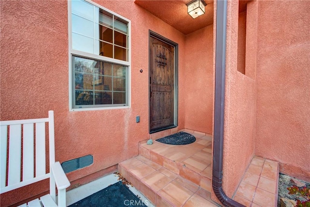 entrance to property featuring stucco siding