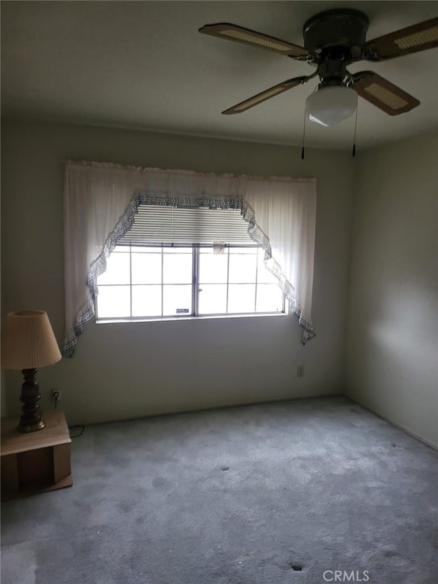 empty room with carpet flooring and a ceiling fan