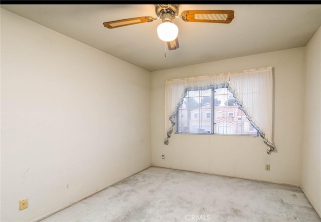 carpeted spare room featuring a ceiling fan