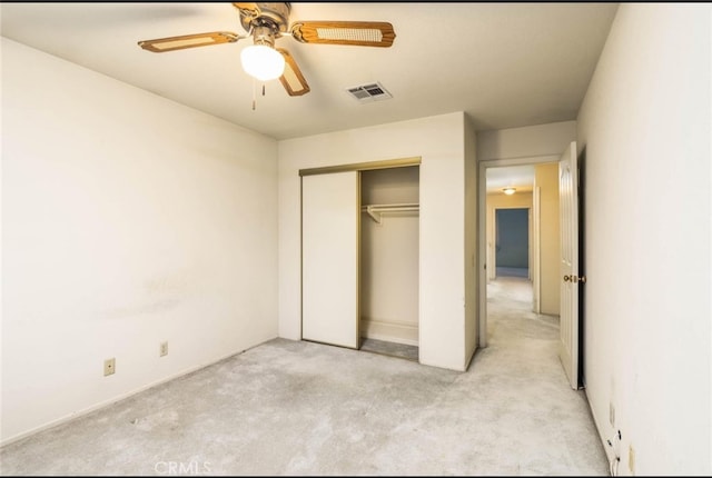 unfurnished bedroom featuring visible vents, light colored carpet, a closet, and ceiling fan