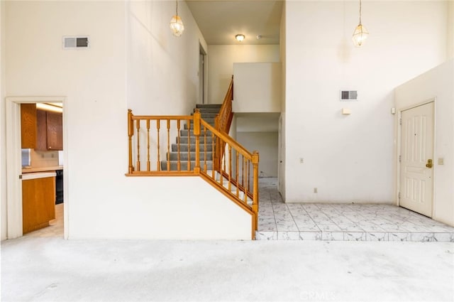 interior space with a high ceiling, carpet, and visible vents