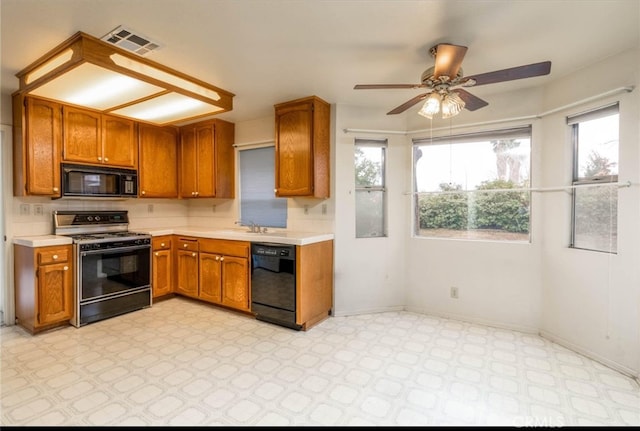 kitchen with visible vents, black appliances, brown cabinetry, light countertops, and light floors