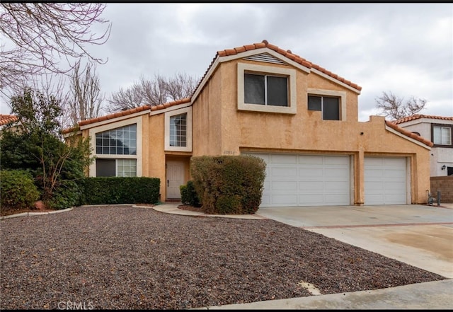 view of front of home featuring a tiled roof, a garage, driveway, and stucco siding