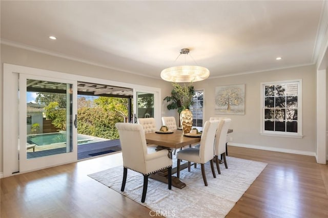 dining room featuring a healthy amount of sunlight, crown molding, and wood finished floors